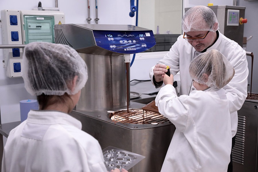 Ateliers. Devant la fontaine de chocolat, petits et grands jouent les maîtres chocolatiers et s’appliquent à fabriquer une tablette.